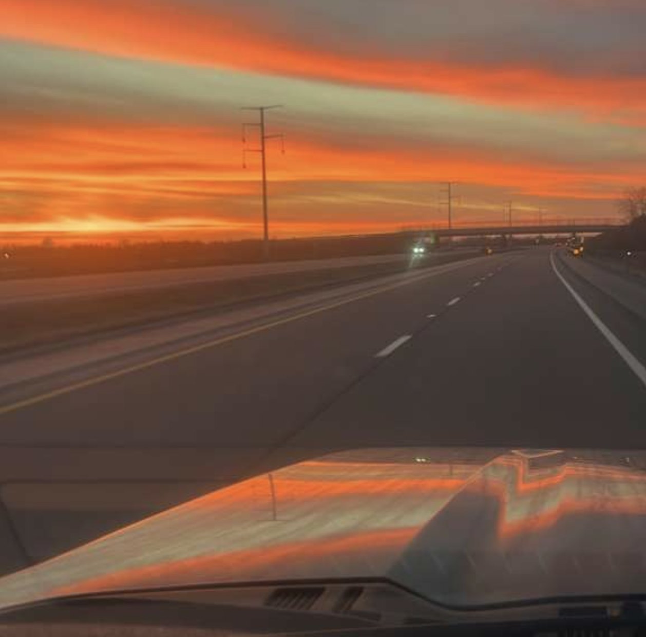 A highway at sunset, seen through the windshield on the drive home.