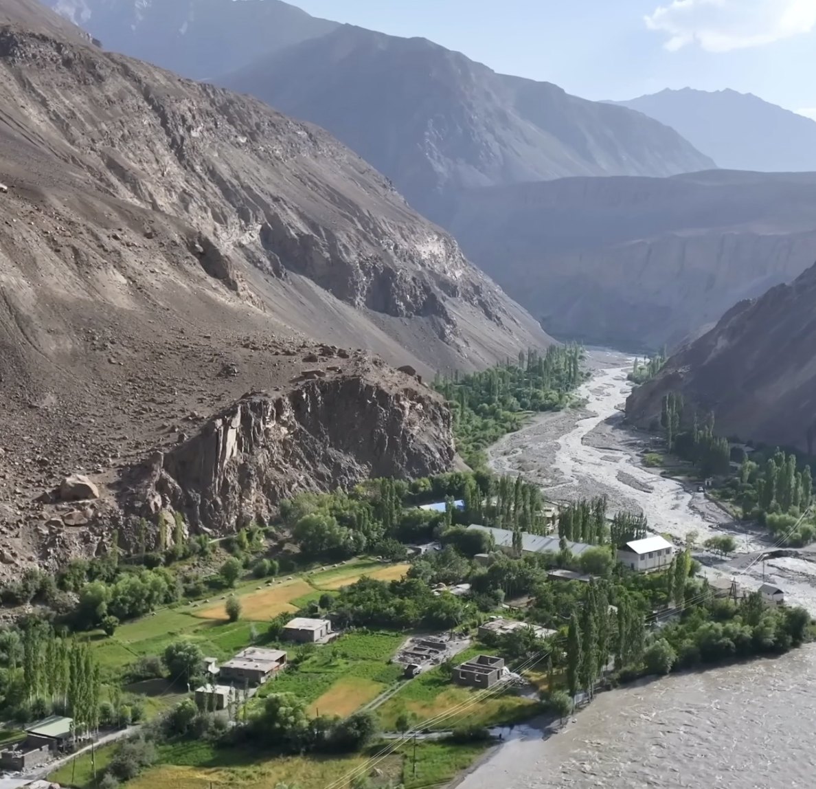 A green river valley between bare mountains.